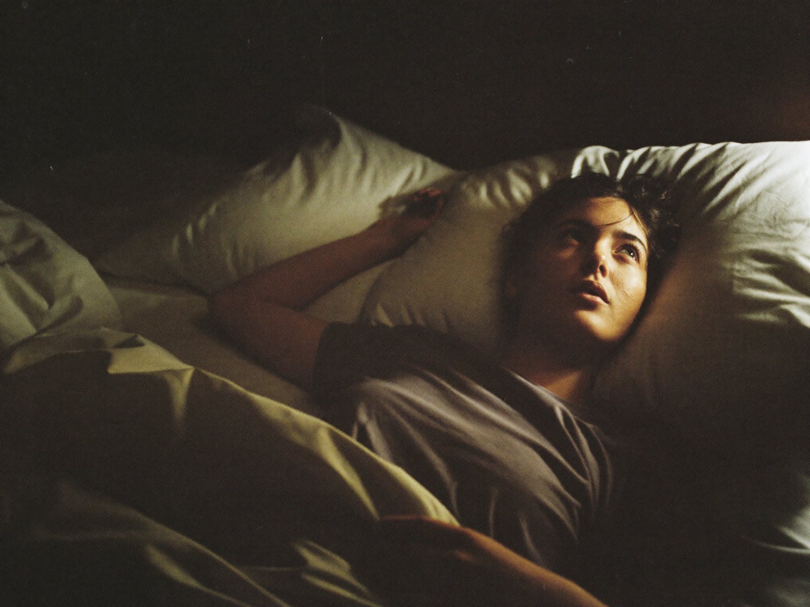 Someone lying awake in the dark at 2 AM, looking at the ceiling